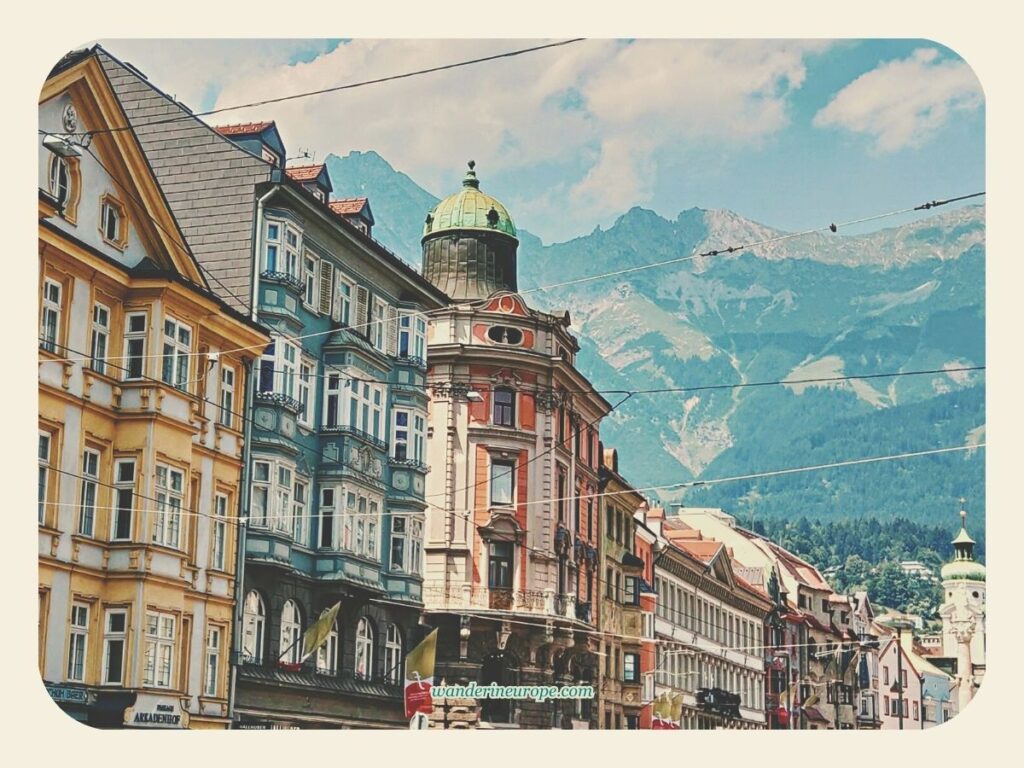 Picture-perfect view of the colorful buildings along Maria-Theresien-Strasse with Nordkette in the backdrop in Old Town Innsbruck, Austria