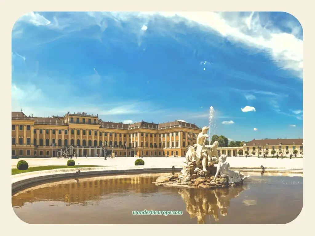 Reflection of the facade of the Schönbrunn Palace from the Parade Court Fountains, first photo spot of Schönbrunn Palace, Vienna, Austria