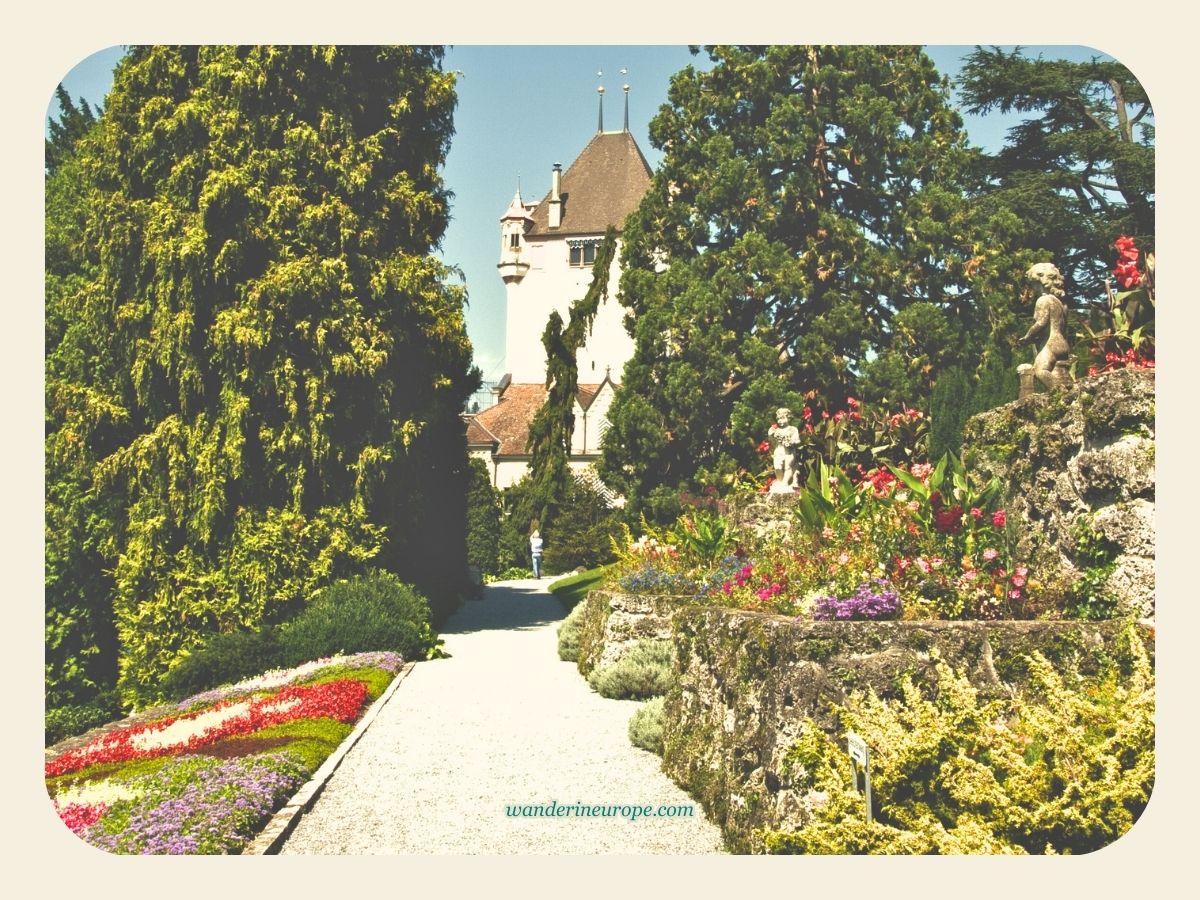 Tall trees and the colorful plants inside Oberhofen Castle’s Park in Thun, Switzerland